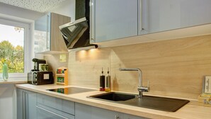 Eine moderne Küche mit einer doppelten Spüle, Edelstahlgeräten und hellen Holzschränken.