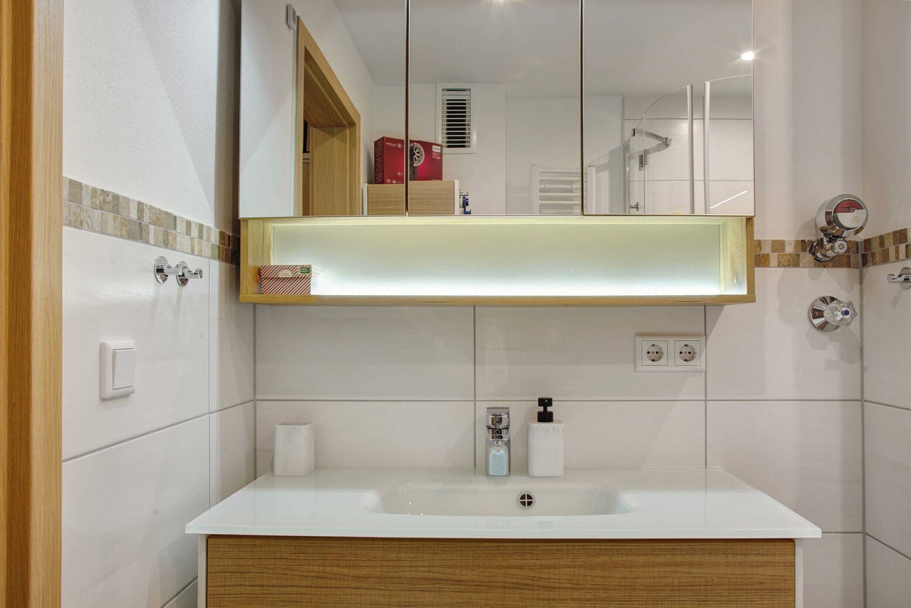 A bathroom with a white sink, a mirror, and a towel rack.