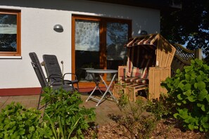 A patio with wicker furniture, a table, and a chair.
