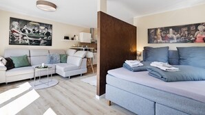 Una sala de estar moderna con un sofá, una mesa de centro y un comedor con una mesa y sillas.