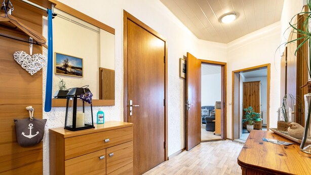 A hallway with wooden cabinets, a mirror, and a door leading to another room. - Apartment 'Groth's' with Shared Terrace, Shared Garden and Wi-Fi (Lunden)