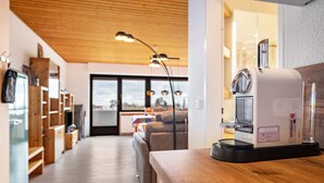 Une cuisine moderne avec des meubles en bois, une machine à café et une vue sur le salon.
