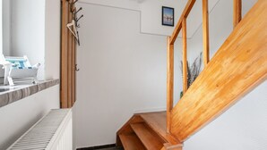 Een houten trap met een witte muur en een deur.