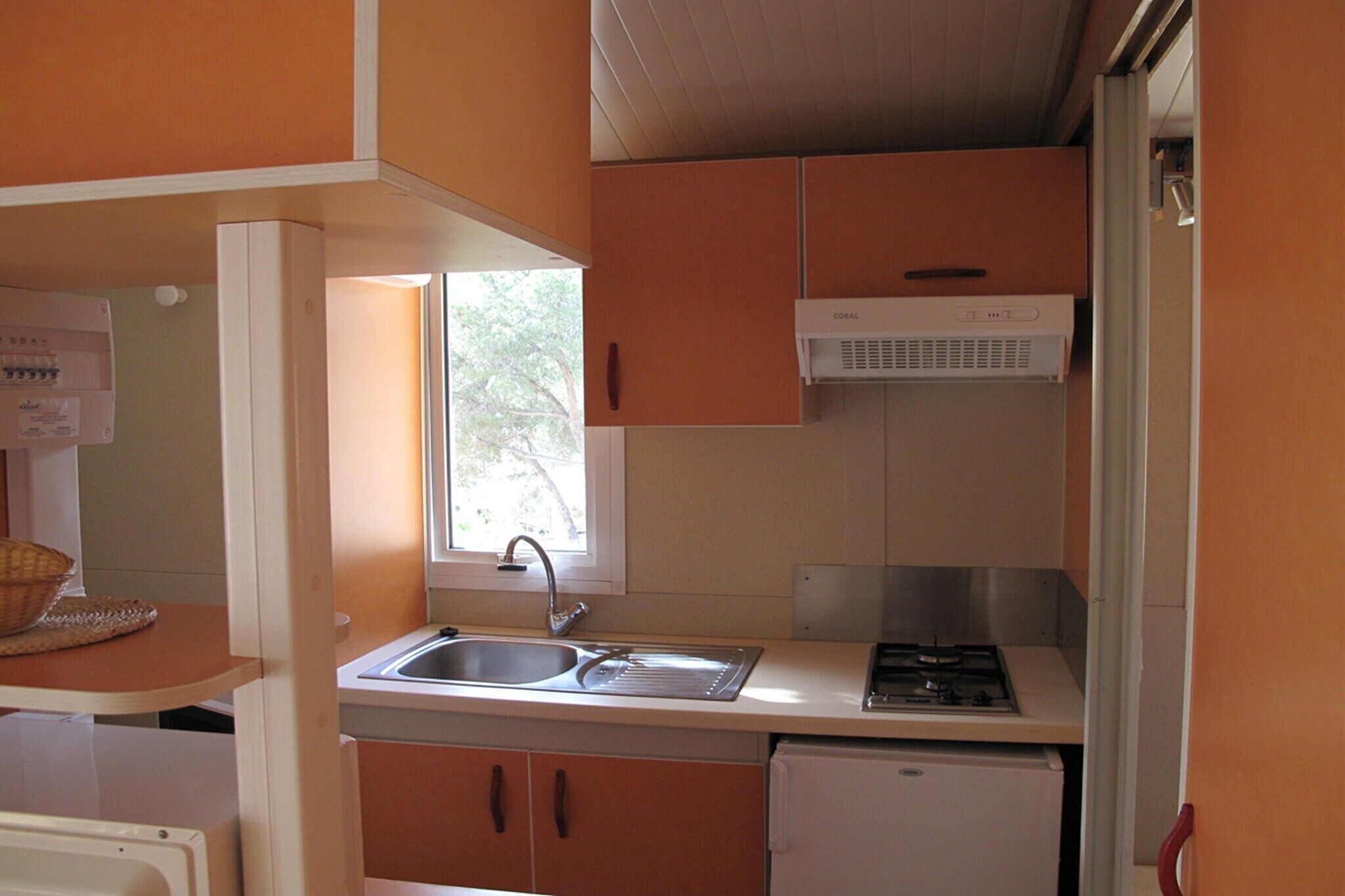 A compact kitchen with a sink, stove, and a window providing natural light.