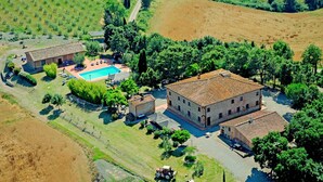 An aerial view of a property with a swimming pool, multiple buildings, and surrounding agricultural fields. - Flat with swimming pool and air conditioning (Peccioli)