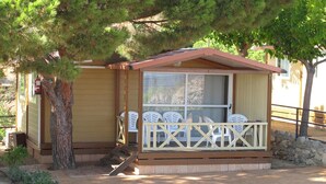 Eine kleine Holzhütte mit Veranda, Fenster und Tür.