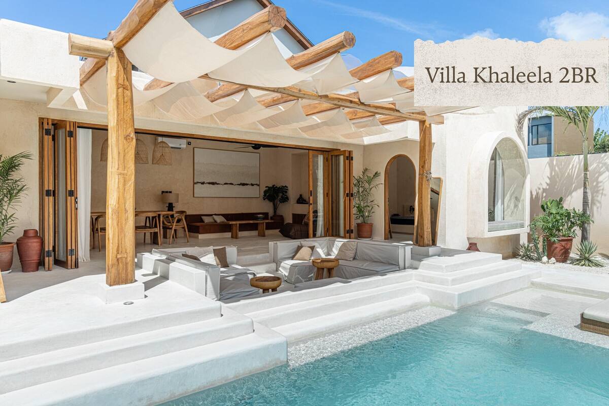 Eine Villa mit Pool, Außenbereich mit Sitzgelegenheiten und einer überdachten Terrasse.