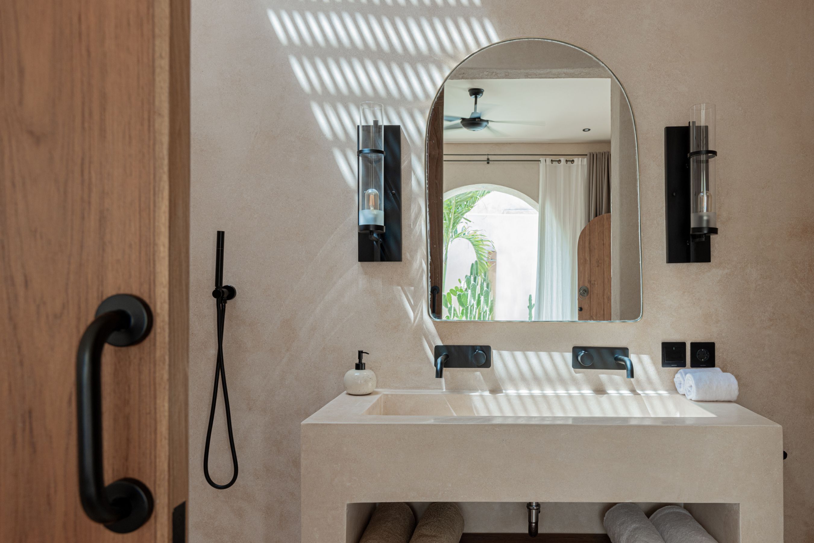Ein modernes Badezimmer mit einem großen Spiegel, einem Waschbecken und einem Handtuchhalter.