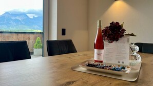 A dining table with a wine bottle, menu, and decorative flowers.