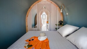 A bedroom with a bed, a nightstand, a lamp, and a window. - Premium tent lodge for family (Tarragona)