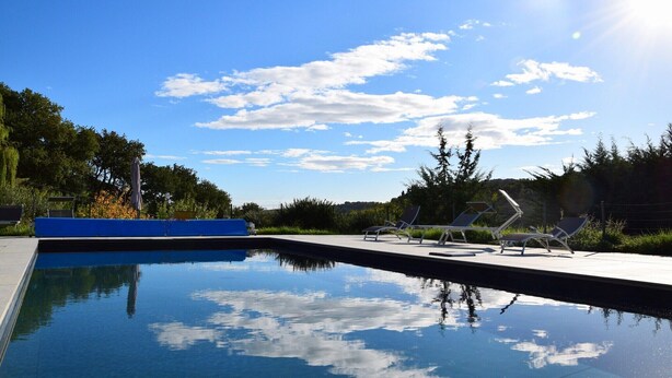 A swimming pool with lounge chairs and a blue deck. - Apartment in Marche with Pool near Adriatic (Lampedona)