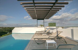 A rooftop pool area with a pergola, lounge chairs, and a view of the cityscape. - Comfortable, Spacious Penthouse- 2 Bedrooms- 7 People (Tulum)