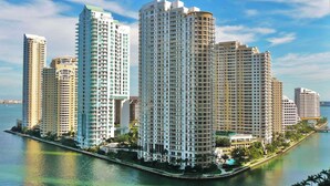 A high-rise hotel with multiple floors, a waterfront location, and a marina in the background.