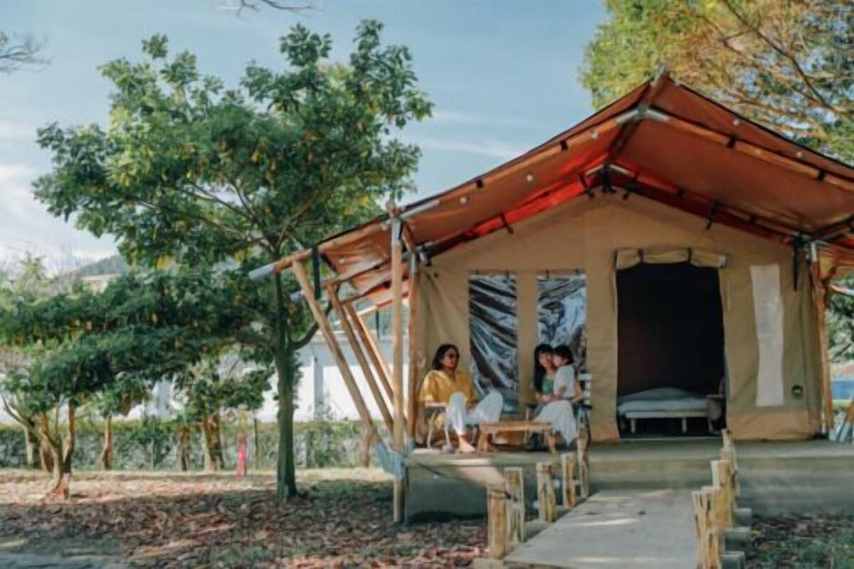 Une structure en forme de tente, dotée d’un espace de repos couvert et d’un lit à l’intérieur.