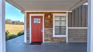 Una casa con puerta roja, fachada de piedra y madera, y el número '34A' en la pared.