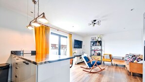 A modern apartment with a kitchen, living area, and a balcony.