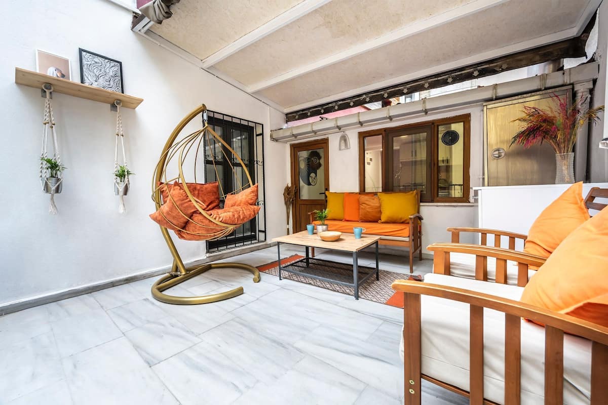 A living room with a hanging chair, a sofa, and a coffee table.