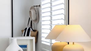 A mirror with a black frame, a white vase, and a lamp on a wooden cabinet. - Regatta 19 - Top Floor Luxury.  Spectacular Water Views | Breathtaking Sunsets  (Forster)