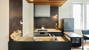 Eine kompakte Küche mit modernem Design, ausgestattet mit einem Einbauherd, einer Spüle und einem Kühlschrank.
