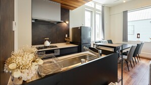 Eine moderne Küche mit Holzboden, Einbauherd und Essbereich mit Tisch und Stühlen.