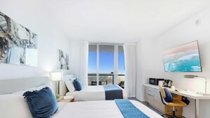 Une chambre d’hôtel avec deux lits, un bureau, une télévision et une grande fenêtre donnant sur la ville.