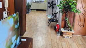 A room with wooden walls, a wooden floor, a television, a fan, a potted plant, and a window with blinds. - Disco PangPang GuestHouse (Foreigners only) (Incheon)