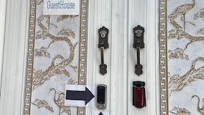 A double door with intricate designs, a 'GuestHouse' sign, and directional arrows. - Disco PangPang GuestHouse (Foreigners only) (Incheon)