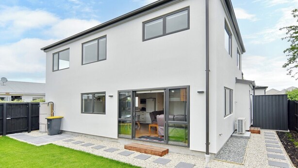 A modern two-story house with a large glass door entrance, a small porch, and a well-maintained garden. - Brand-new, townhouse - walking distance to Westfield Mall (Christchurch)