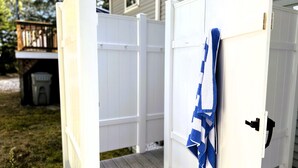 A white wooden deck with a blue and white towel hanging on the door. - New! Sandy Point-Private beach/Dog Friendly (Eastham)