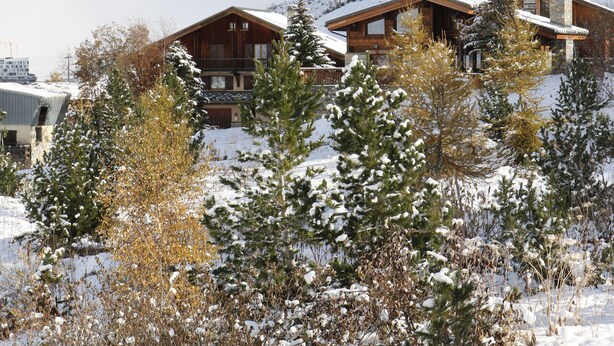 A snow-covered mountain with a wooden lodge in the foreground.