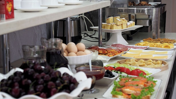 A buffet with various food items including eggs, meats, and salads.
