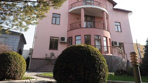 A pink building with balconies and a sign that reads "AZIYA RYATB".