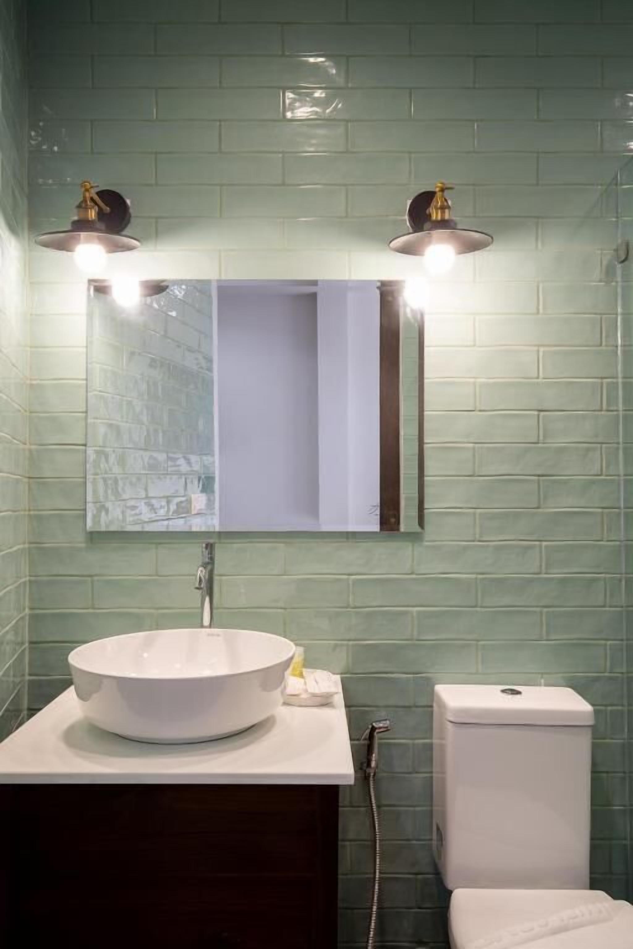 A bathroom with a white sink, a mirror, and a toilet.