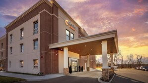 A hotel with a brick facade, a covered entrance, and a sign indicating it is a Comfort Suites hotel. - Comfort Suites Central Valley - Woodbury (Central Valley)