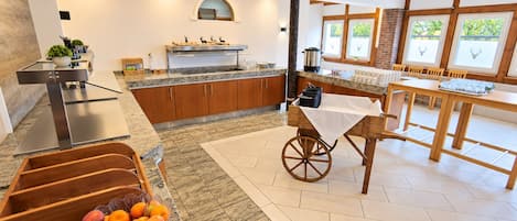 A modern kitchen with granite countertops, wooden cabinets, and a dining area with a table and chairs.