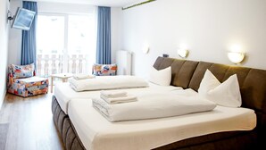 Une chambre d’hôtel avec deux lits, un canapé, une télévision et un balcon avec vue.