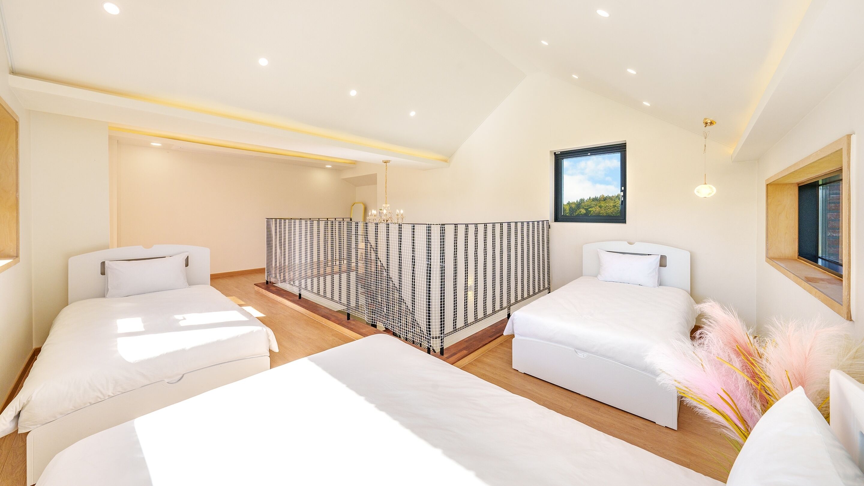 A modern hotel room with two beds, a balcony, and a view of the outdoors.