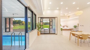 Une chambre d’hôtel moderne dotée d’une piscine, d’un coin repas et d’une chambre à coucher.