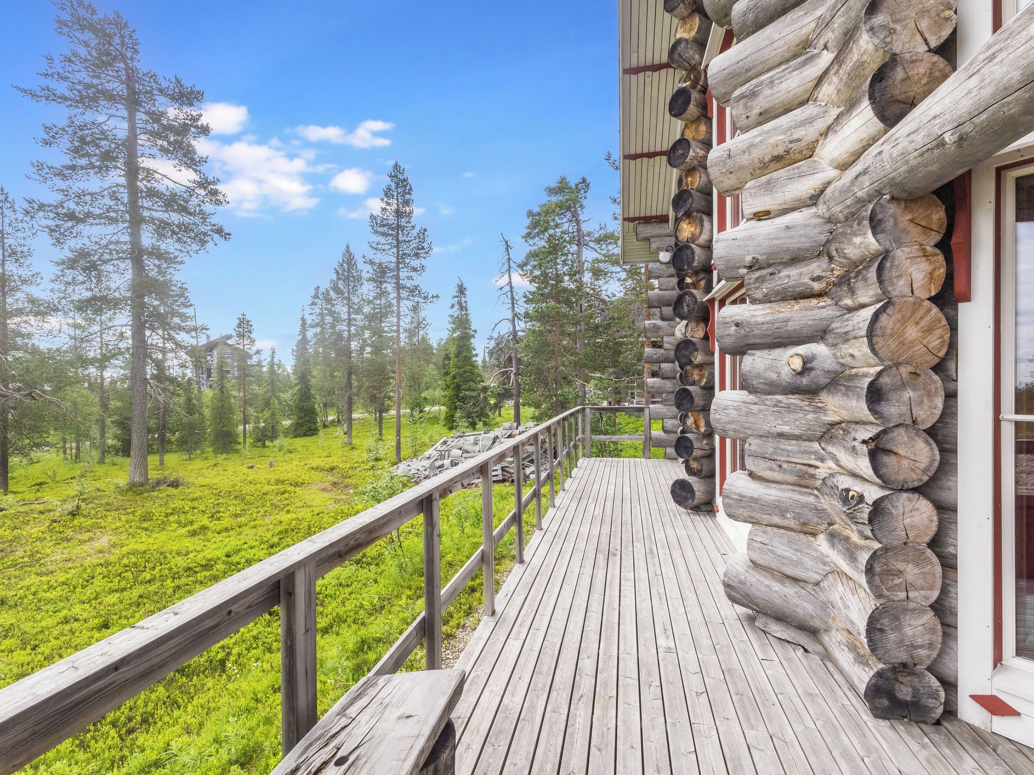 Eine Holzterrasse mit Blick auf einen Wald.