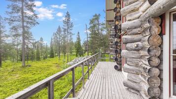 Eine Holzterrasse mit Blick auf einen Wald.