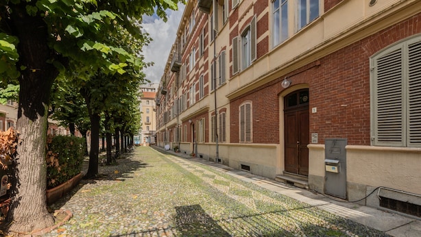 Una calle adoquinada bordeada de árboles y edificios.