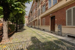 A cobblestone street lined with trees and buildings. - Crocetta Nest by Wonderful Italy (Turin)