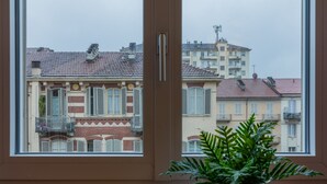 Una ventana con vistas a un edificio con varios balcones y contraventanas.