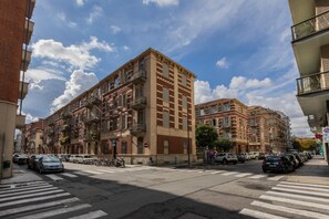 A street view with multi-story buildings, a crosswalk, and parked cars. - Crocetta Nest by Wonderful Italy (Turin)