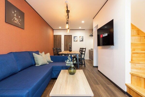Relax in this stylish living space with a sofa, dining table, and flat-screen TV.