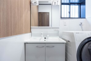 Convenient laundry facilities with washing machine and sink.