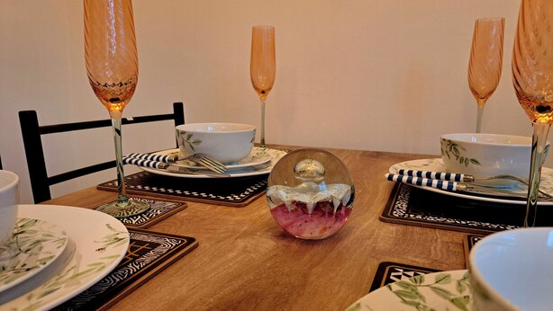 A dining table with a floral pattern, a decorative glass bowl, and matching cutlery. - 2 Bedroom House in Leeds - Sleeps 5, Wifi, Pets (Leeds)
