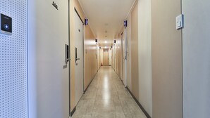 A hotel corridor with doors labeled 500 and 510, a fire extinguisher, and a security panel on the left wall. - Anyang Livera (Anyang)
