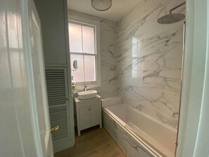 Chuveiro, secador de cabelo, toalhas de banho, papel higiênico