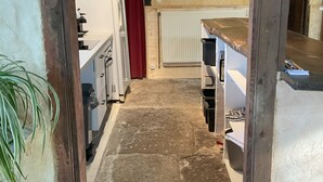 A narrow hallway with a wooden door frame, a radiator, and a red curtain. - Loca saiso/vac/Séjour : 120 m² in an authentic, restored farmhouse (Goutrens)